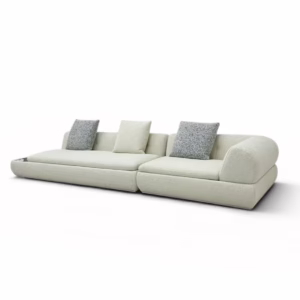 正面全景月亮沙發，呈現兩個寬大座位和右側圓潤扶手，搭配三個幾何與白色抱枕。羊羔絨材質營造侘寂風質感